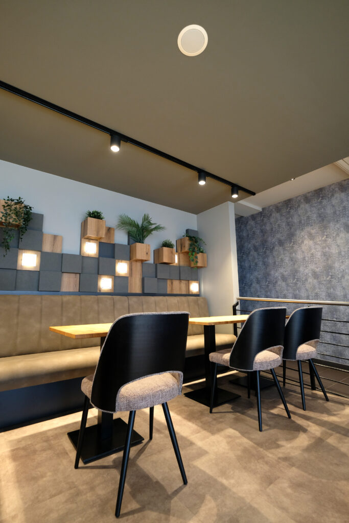 Bild Sitzbereich mit toller beleuchteter Pflanzenwand. Das Design der Wandgestaltung ist in der Form eines Periodensystems.